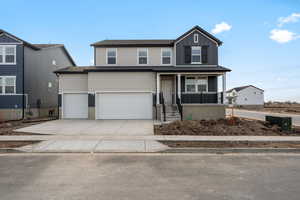 View of front facade with a porch and a garage