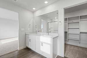 Bathroom with vanity, wood-type flooring, and a shower with door