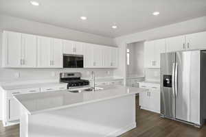 Kitchen with a kitchen island with sink, white cabinets, sink, dark hardwood / wood-style floors, and stainless steel appliances