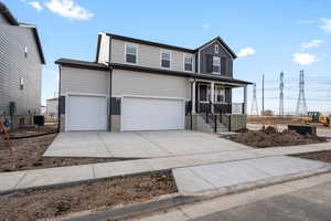 Front of property featuring a porch, central AC, and a garage