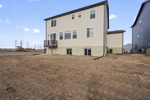 Rear view of property with cooling unit and a balcony