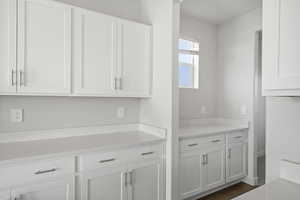 Interior space featuring white cabinetry and dark hardwood / wood-style flooring