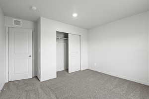 Unfurnished bedroom featuring carpet floors and a closet