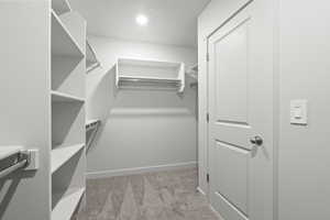 Spacious closet with light colored carpet