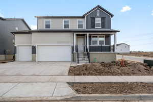 View of property with a porch and a garage