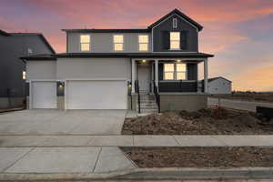 Front of property with a porch and a garage