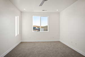 Carpeted empty room featuring ceiling fan