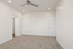 Carpeted empty room featuring ceiling fan