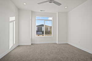 Carpeted spare room featuring ceiling fan