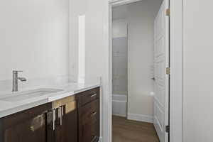 Bathroom with hardwood / wood-style floors, vanity, and tiled shower / bath combo