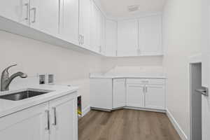 Washroom with washer hookup, sink, cabinets, and light wood-type flooring