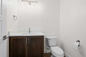 Bathroom featuring vanity, hardwood / wood-style flooring, and toilet