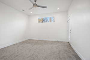 Carpeted spare room featuring ceiling fan