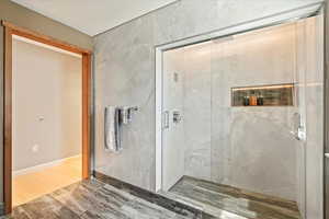 Bathroom with walk in shower and hardwood / wood-style floors