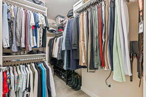 Spacious closet featuring light colored carpet