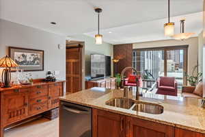 Kitchen featuring a barn door, decorative light fixtures, sink, and light hardwood / wood-style flooring