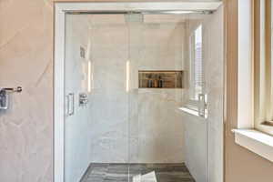 Bathroom featuring a healthy amount of sunlight and a shower with door