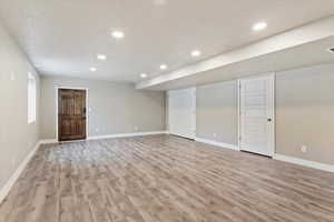 Finished basement featuring spacious family room and light hardwood / wood-style floors