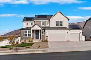 View of front of home featuring solar panels, a mountain view, and a garage