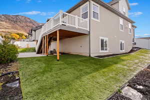 Back NW corner of property with a deck with mountain view and a lawn