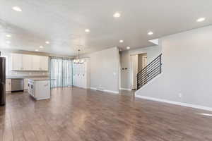 Kitchen featuring stainless steel appliances, a kitchen island, wood-type flooring, and lots of white cabinets