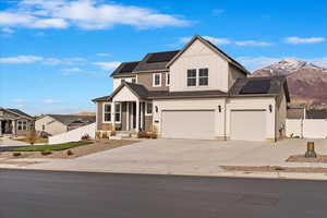 View of front of property featuring solar panels, a mountain view, and a garage