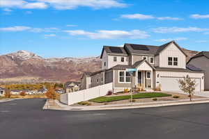 View of front of property featuring a mountain view, a garage, and solar panels