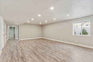 Family room with a textured ceiling and light hardwood / wood-style flooring