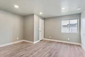 Bedroom featuring light wood-type flooring and a textured ceiling