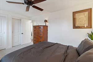 Bedroom with ceiling fan and light carpet