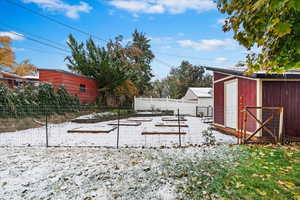 Yard layered in snow with a storage unit