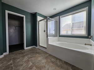 Bathroom featuring shower with separate bathtub, tile patterned floors, and a textured ceiling