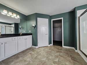 Bathroom with tile patterned flooring, vanity, and an enclosed shower