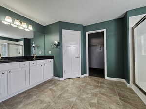 Bathroom with tile patterned flooring, vanity, and walk in shower