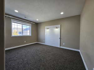 Carpeted empty room with a textured ceiling