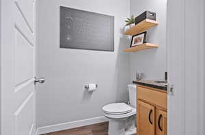 Bathroom with vanity, hardwood / wood-style floors, and toilet