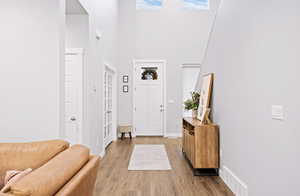 Entryway featuring a towering ceiling and light hardwood / wood-style floors