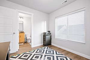 Miscellaneous room with a textured ceiling and light hardwood / wood-style flooring