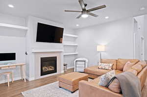 Living room featuring a fireplace, light hardwood / wood-style flooring, and ceiling fan