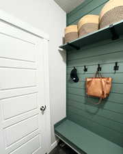 Mudroom featuring wood walls