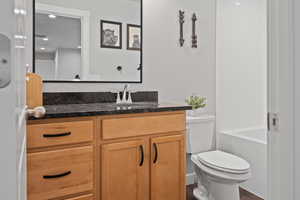 Bathroom featuring vanity, toilet, and wood-type flooring