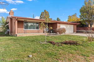 Ranch-style home with a front lawn and a garage