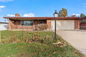 Ranch-style house with a front lawn and a garage