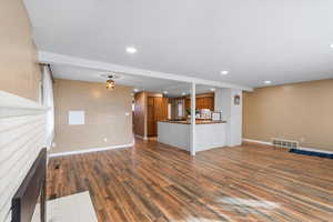 Unfurnished living room featuring dark wood-type flooring