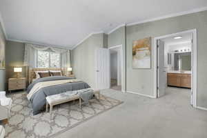 Bedroom with connected bathroom, light colored carpet, crown molding, and lofted ceiling