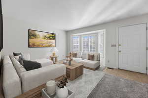 Living room with light tile patterned floors and a textured ceiling