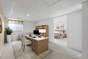 Carpeted home office featuring a paneled ceiling