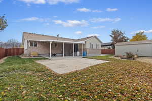 Back of property with a yard and a patio area