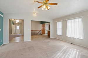 Carpeted spare room with vaulted ceiling and ceiling fan