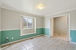 Tiled spare room with ornamental molding